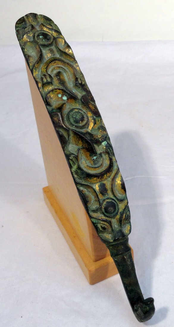 Chinese Bronze Warring States Gilt Bronze Belt Hook: Antique Chinese gilt bronze warring states period belt buckle hook with raised Taotie style design. This belt buckle comes from the estate of collector and Fulbright scholar, Professor Peter Pelletier