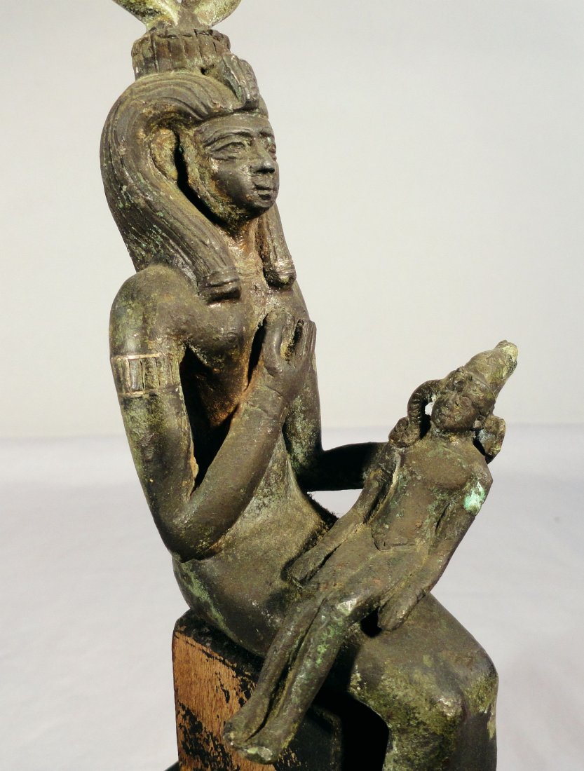 Antique Egyptian Bronze Statuette Isis and Horus: Seated bronze statuette of Egyptian goddess Isis suckling the infant Horus. This early sculpture also appears to have silver inlaid details on the arms and hair and necklace of Isis. The bronze has pa