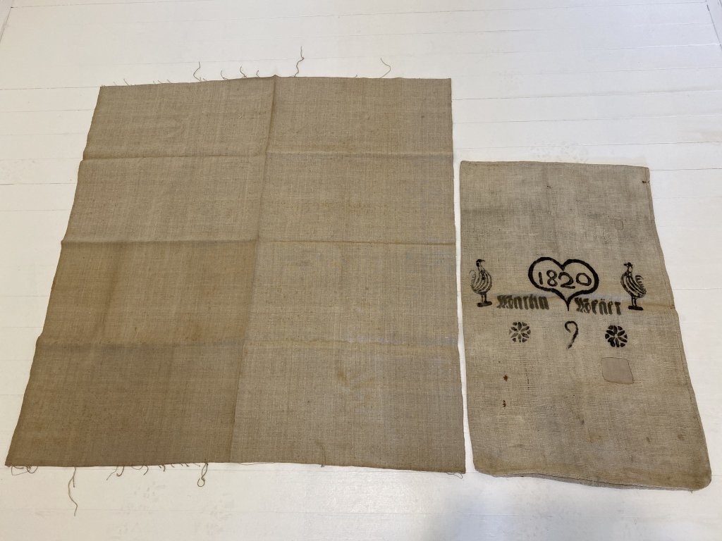 Dated 1820 folk art feed bag & remnant.: Minor staining, patches on the feed bag. Remnant measures approximately 42” x 40.5”. Bag measures approximately 31.5” x 19.75”.