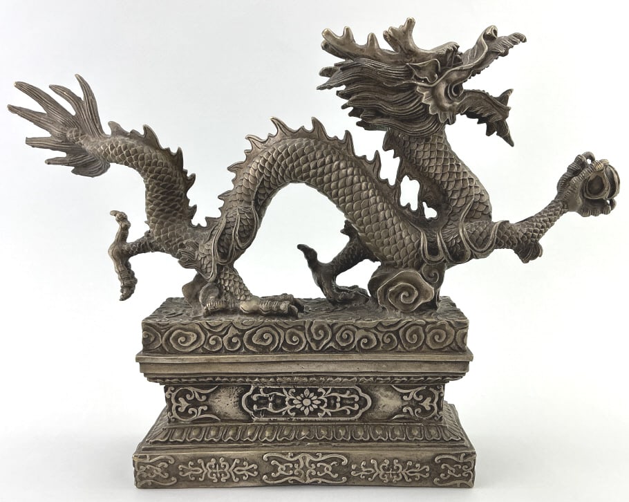 Antique Chinese Feng Shui Dragon Statue.: 10.5"Hx14.5"L. Silvered copper serpentine body dragon clasping a flaming pearl in front claw, mounted on a decorative pillar base. Condition: Very good. **LOCAL PICKUP MUST BE BY APPT ONLY POSTAUCTION