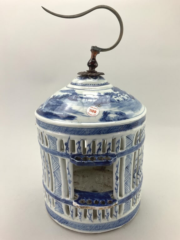 Chinese Blue and White Porcelain Bird Cage.: Measures 15 inches high x 7 inches wide. Late 19th/early 20th century, cylinder form with domed top, figural and landscape decoration. Original metal hanging hook. Condition: Very good, missing door p