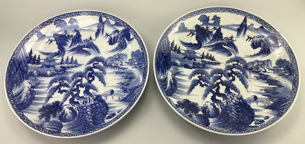 Pair of Japanese Meiji Style Porcelain Chargers.: Measure 18 inches in diameter. Unsigned, Japanese, 20th century. 2 matching large blue and white porcelain chargers with blue under-glaze hand painted decoration on white ground depicting traditional 