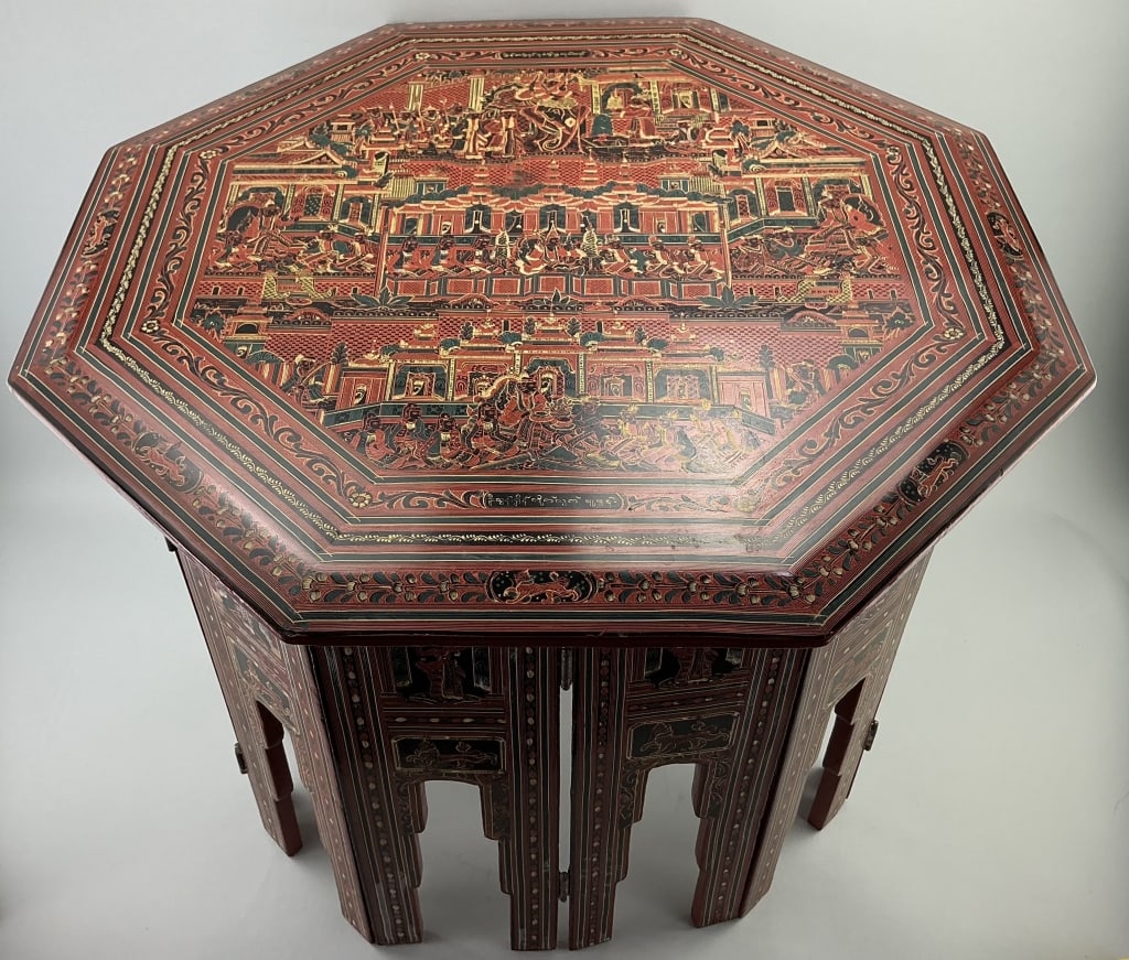 Burmese Yun-De Lacquer Octagonal Folding Table.: Measures 19 inches high by 24 inches wide. Early 20th century. Hand-painted with elaborate temple scenes and triple floral and foliate borders. Condition: Very good with minor wear.**LOCAL PICKUP MUST
