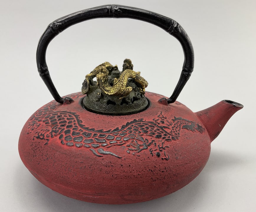 Cast Iron Japanese Dragon Motif Teapot.: Measures 7 inches high and 8 inch diameter. Squat bulbous red-painted body with embossed serpentine dragon design. Finely sculptured bronze twin dragon dome-form lid. Cast 2 character signature. Condi
