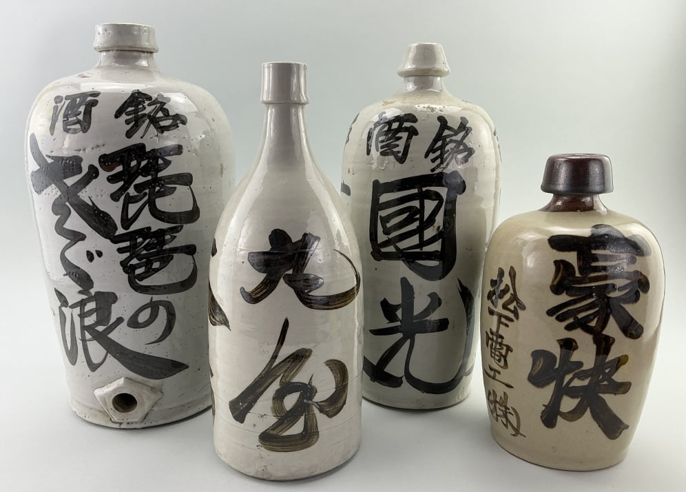 4 Japanese Pottery Sake Bottles.: Largest bottle measures 14 inches high. 4 various form antique Japanese sake bottles (tokkuri) showcases traditional craftsmanship and artistry. Hand-thrown from stoneware clay, the surface is adorned