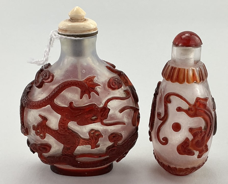 2 Chinese Peking Glass Snuff Bottles.: Measures 3 inches high. Both have red overlay of a various form dragon, over a semi-opaque white ground. Condition: Very good. **LOCAL PICKUP MUST BE BY APPT ONLY POST AUCTION ONLY ON SPECIFIC DATES:C