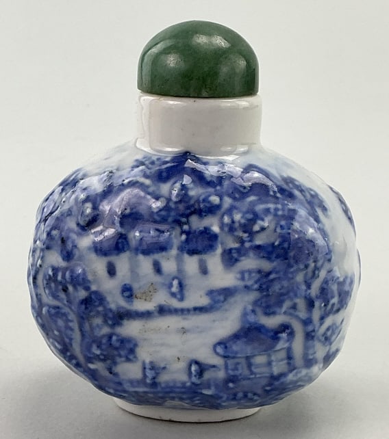 Chinese Blue & White Porcelain Snuff Bottle.: Measures 3.5 inches high. Qianlong blue under-glaze six-character mark (1736-1795). Chinese Blue and White Molded Porcelain Snuff Bottle, embossed with waterside village scenes. Jade stopper. Conditio