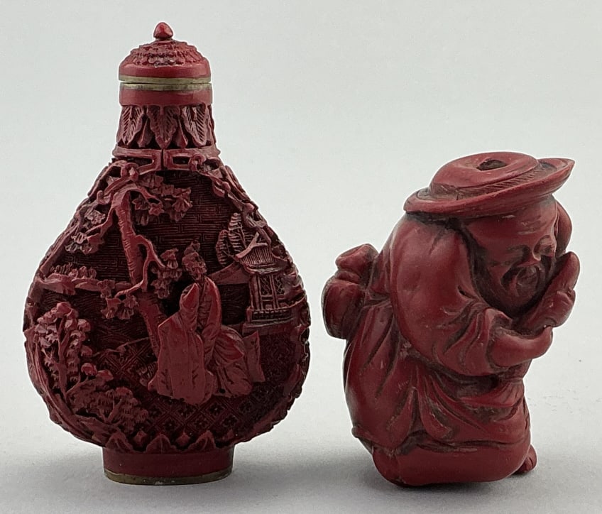 2 Vintage Chinese Cinnabar/Resin Snuff Bottles.: Measure 2-3 inches high. Both are carved and lacquered cinnabar. 1st: Pear-shaped bottle with double sided female in garden/courtyard scenes. Base is signed in seal script. 2nd: Wiseman holding koi fi