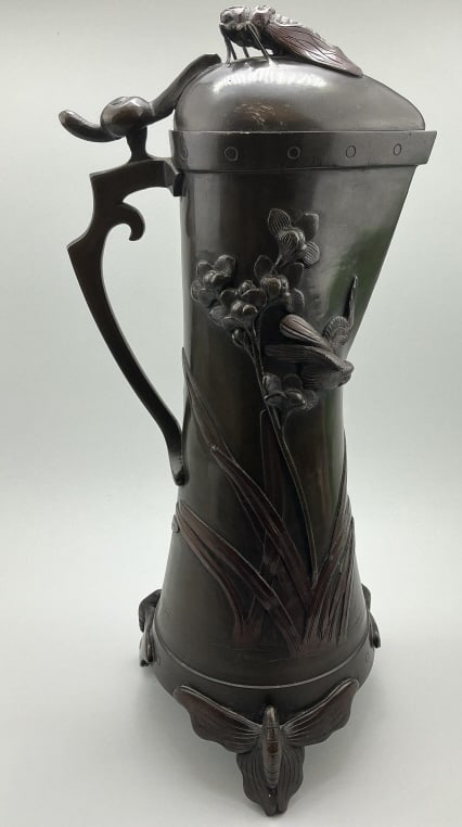 Japanese Meiji Period Bronze Ewer.: Measures 18 inches high. 19th century with cicada finial on lid, snail adorned handle, body with raised bird and flowers and butterfly feet. Condition: Very good with darkened patina.**LOCAL PICKUP MU