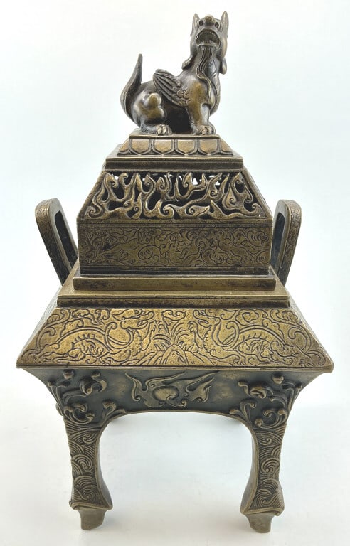 Chinese Qianlong Bronze Censer w/ Rui Shou Finial.: Measures 12 inches high. Square form with with open handles, incised dragon, embossed flaming pearls and claw feet. Qianlong 4-character mark on base. Condition: Good with dark patina.**LOCAL PICKUP M