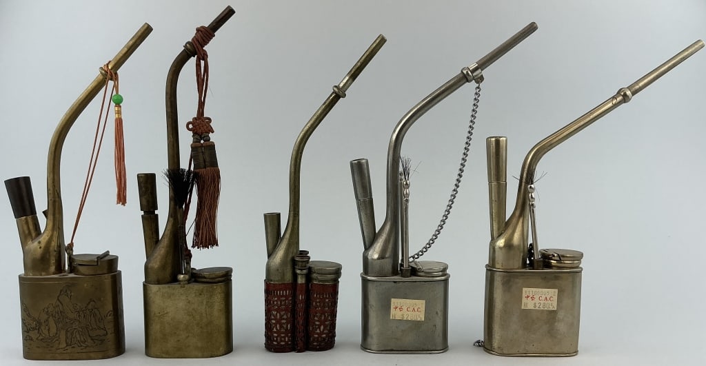 5 Various Antique Chinese Opium Water Pipes.: Measure 9.5 to 10 inches high. All appear to be brass, some are nickel plated. One with incised scenes of travelers in a landscape. One with pierced leather covering. Condition: Good with wear, someac