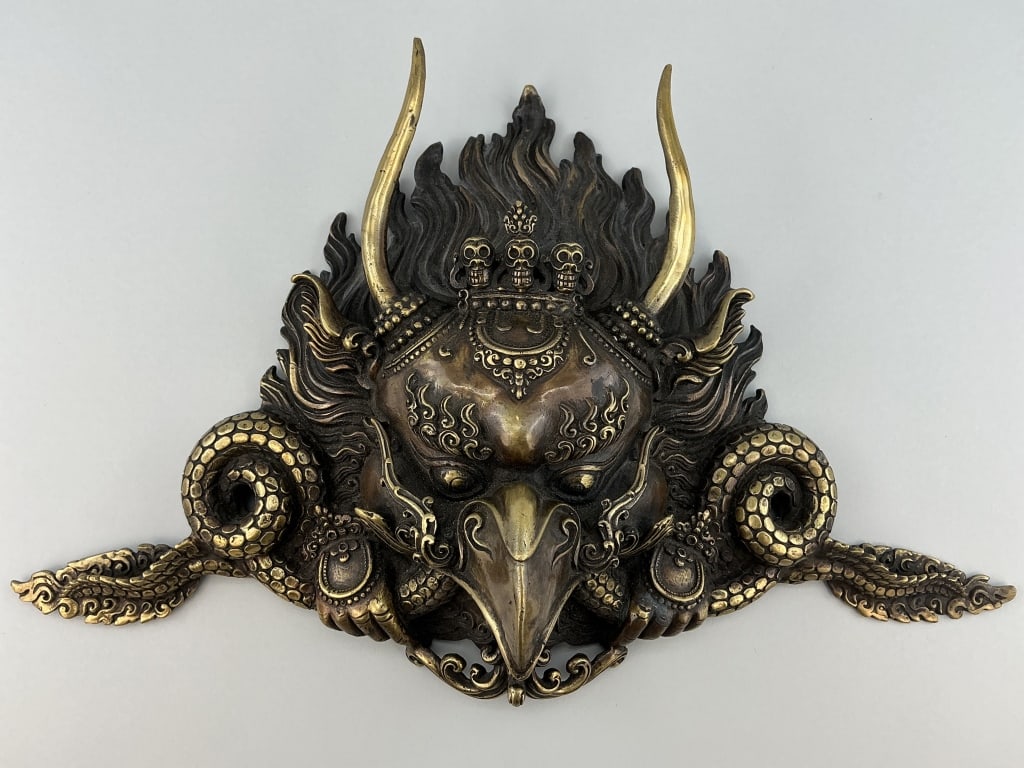 Tibetan Buddhist Brass Garuda Mask.: Measures 15 inches wide. Crafted in Nepal, this cast Garuda wall hanging, a celestial bird-like creature with long horns is revered in Buddhist and Hindu traditions. Considered a powerful protector ag