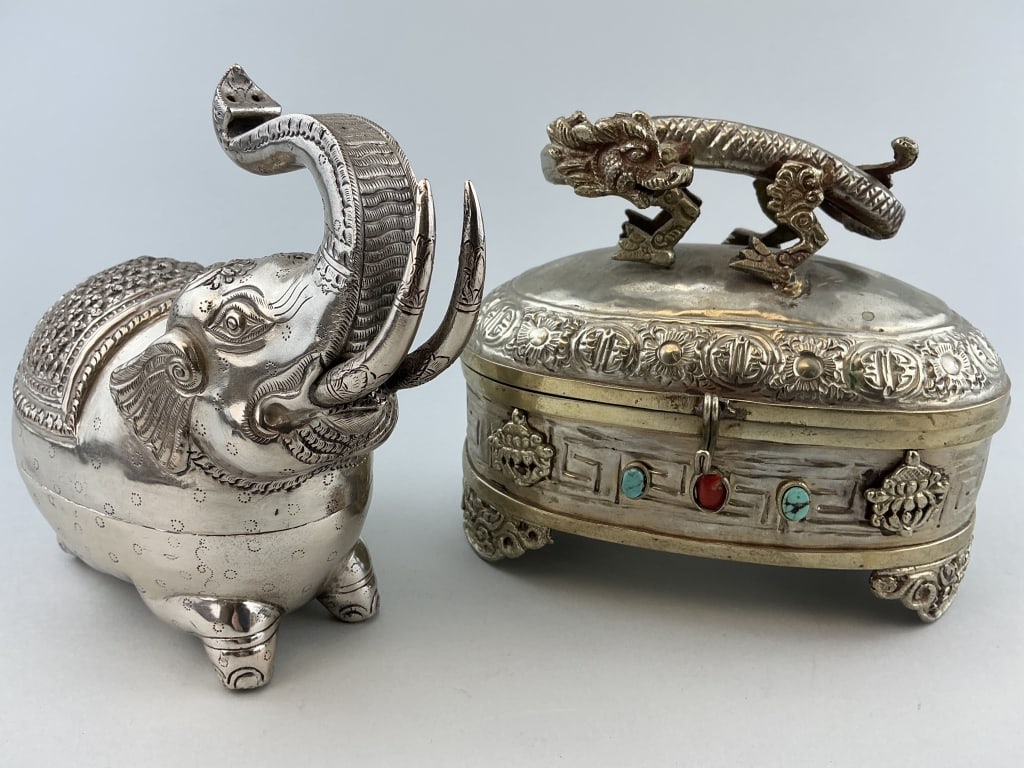2 Antique Silvered Brass Betel Nut Boxes.: Elephant measures 6 inches from front to back. 1st: Indian elephant form with repousse features. 2nd: Chinese oval form with dragon finial and set with turquoise and coral. Condition: Good with light 