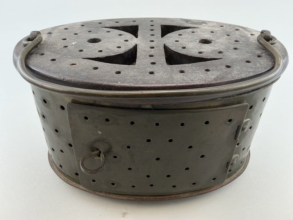 Antique Asian Copper & Rosewood Foot Warmer.: Measures 10 inches wide. Likely Meiji period (1868-1912), oval form with pierced top and sides, swing bail handle, rosewood top, hinged door with ember tray inside. Condition: Good with use wear.**LOC