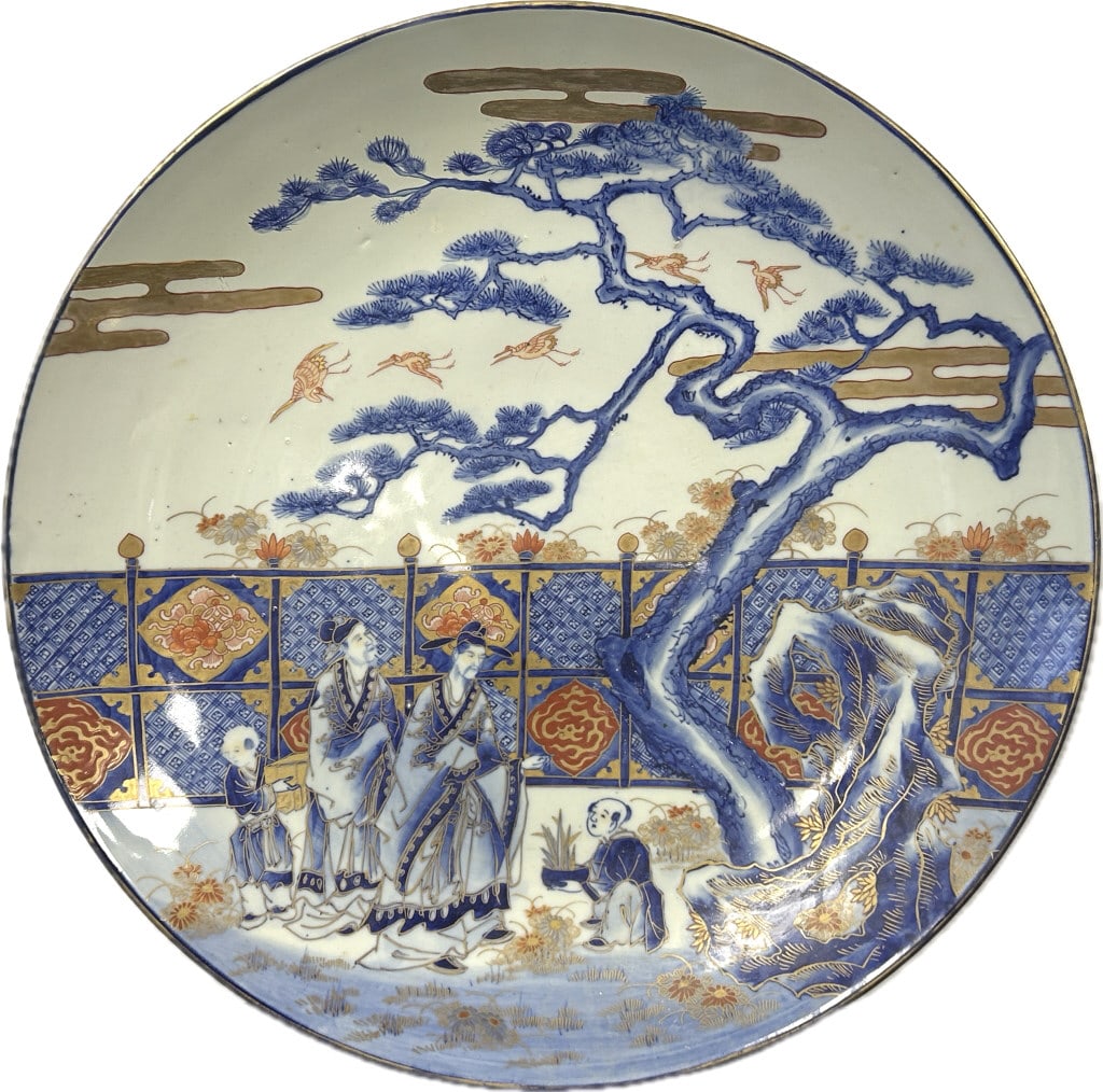 Large Japanese Imari Porcelain Charger.: 18.5 inch diameter. Arita ware with blue underglaze Nanri Yoshitoshi 3 character mark, Bunsei and Tenpo eras (1818-1844). Depicts figures in a garden setting. Yonemasa paper label. Condition: Very goo