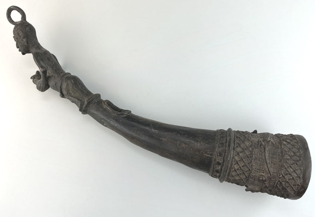 Antique Bamum Figural Bronze Ceremonial Horn.: Measures 19 inches long. Likely early 20th century, Bamum, grassland region in South-west Cameroon. Side-blown trumpet/horn with anthropomophoric figural finial. Condition: Good with wear and dark pat