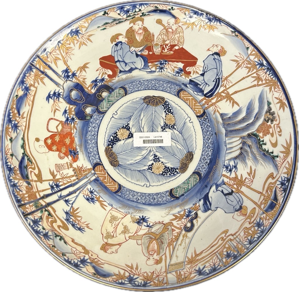 Antique Japanese Imari Porcelain Charger.: 19 inches diameter. Likely Meiji period (1868-1912). Floral and foliate central medallion with traditional Japanese figural scenes Condition: Good, with two chips on the base-ring.**LOCAL PICKUP MUST 