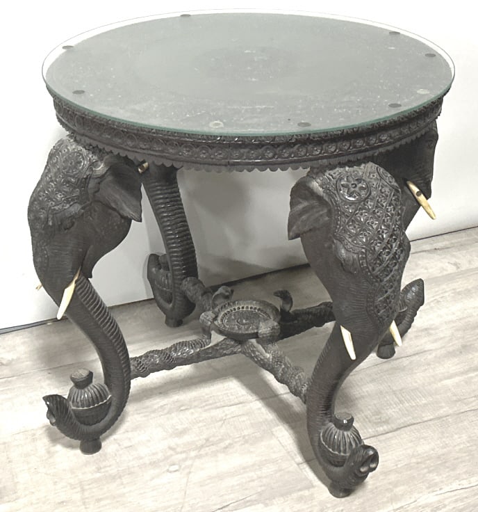 Antique Anglo-Indian Carved Elephant Table.: 25 inches across top x 25.5 inches tall. Approximately 60-75 lbs. Likely Meiji period (1868-1912). Finely carved teakwood with an ebonize finish, features carved elephant head supports with tusks, str