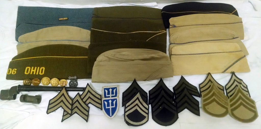 Lot of US Military Hats Buttons Insignia Button Bayonet: This lot features a number of hats as well as some buttons, insignia and a bayonet and scabbard.