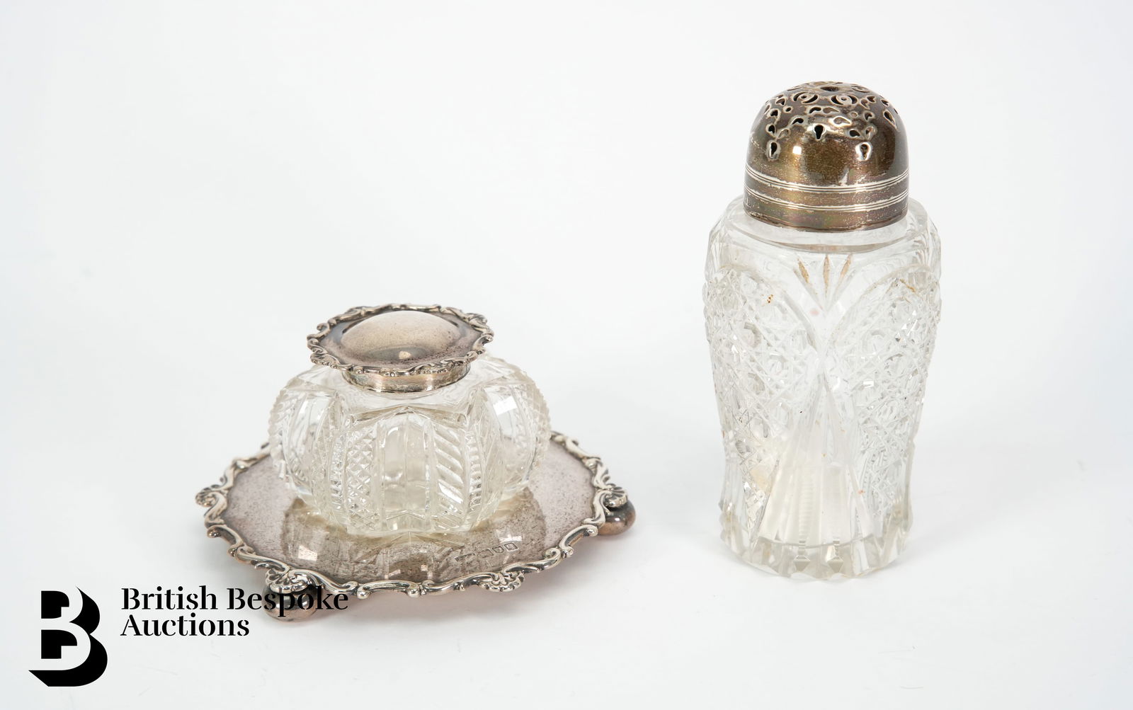 Silver and Cut Glass Ink Stand: A silver and cut glass ink stand, London hallmark dated 1911, mm Philip Hanson Abbot together with a silver topped sugar caster, Birmingham hallmark dated 1904. (2)