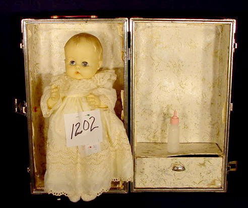 All Vinyl Baby Doll Marked Effanbee 1959 NR: All vinyl baby doll with bottle; marked Effanbee 1959 (Nurser); sleep eyes, open mouth, molded hair. Comes with red and silver metal case. (Hair rubs, eyelashes partially missing, case dented and worn