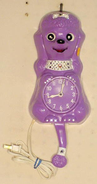 California Clock Co. Purple Poodle Wall Clock: California Clock Co. Purple Poodle Wall Clock: rhinestone collar; bow and tail pendulum; hard plastic; electric. 13" T Running at the time of listing but not guaranteed to continue.