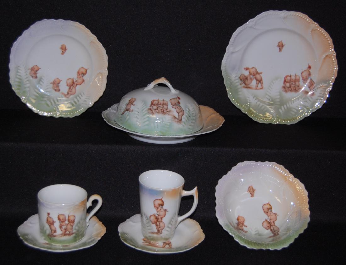 9 Pcs. Rose O'Neill Kewpie China Dishes: 9 Pcs. Rose O'Neill Kewpie China Dishes: They have a green fern pattern with orange highlight. Includes 2 - 8 1/4" Plates; a Butter Dish Dome; a 7" Plate; 2 - 5 3/8" Saucers, a Cereal Bowl; a Tall Cup