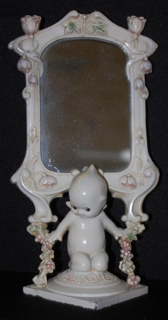Antique Painted Metal Kewpie Mirror: Antique Painted Metal Kewpie Mirror: kneeling Kewpie holding garlands under floral embossed dresser mirror. 10" T x 5 1/2" W (May be some flowers missing from the top.) Sells as is, where is.