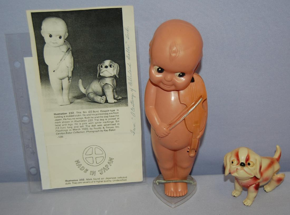 2 Celluloid Items, Kewpie-type Man and Dog: 2 Celluloid Items, Kewpie-type Man and Dog: 1.) Celluloid Kewpie-type holding a molded violin. He has painted features and is marked "Made in Japan".; 2.) Celluloid Dog with jointed head and limbs and