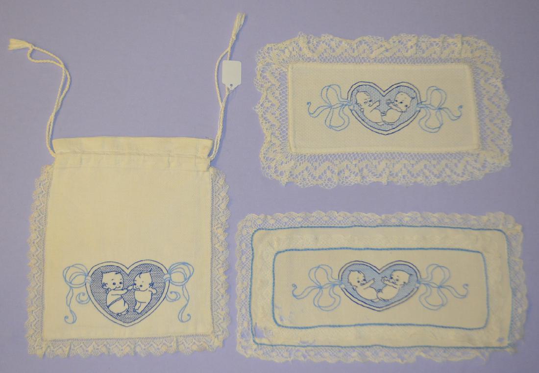 3 Vintage Embroidered Kewpie Items: 3 Vintage Embroidered Kewpie Items: Includes a drawstring bag with Kewpies with music and 2 rectangular doilies. All sell as is, where is.