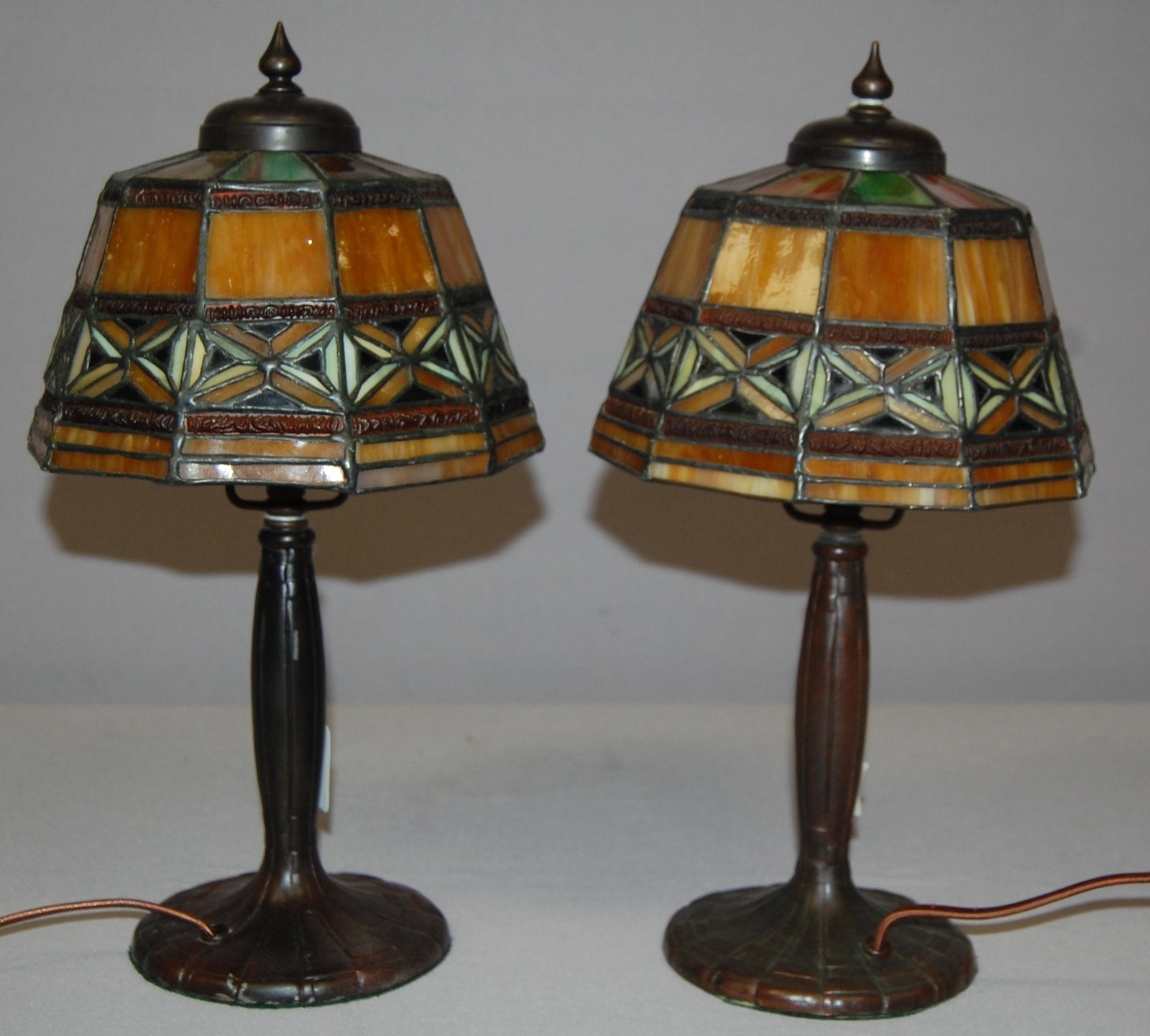 Pair of Geometric Slag Glass Lamps. 10 panel mulitcolor: Pair of Geometric Slag Glass Lamps. 10 panel mulitcolor slag glass shades on ornate bases w/ bottom felt baring Handel Lamps tags.