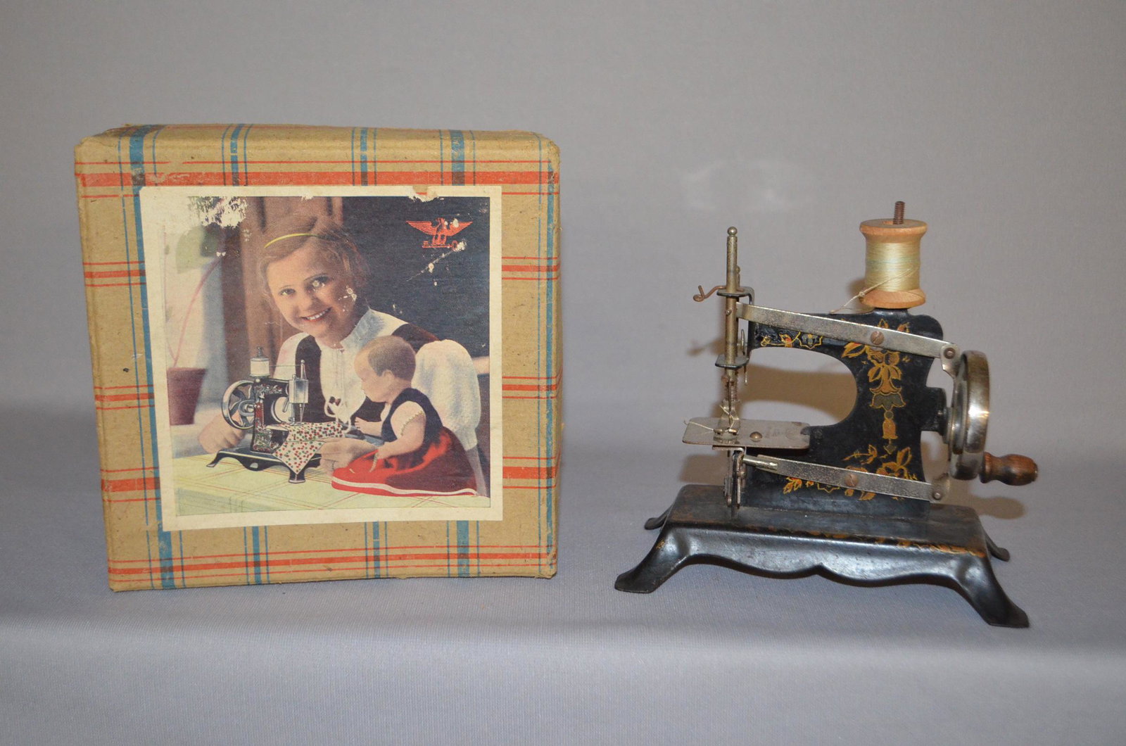 Antique Child's Sewing Machine w/ Orig. Box: painted: Antique Child's Sewing Machine w/ Orig. Box: painted iron and nickel sewing machine, marked Made in Germany, box has some tears and damage, in played w/ condition, missing some paint, very nice for it