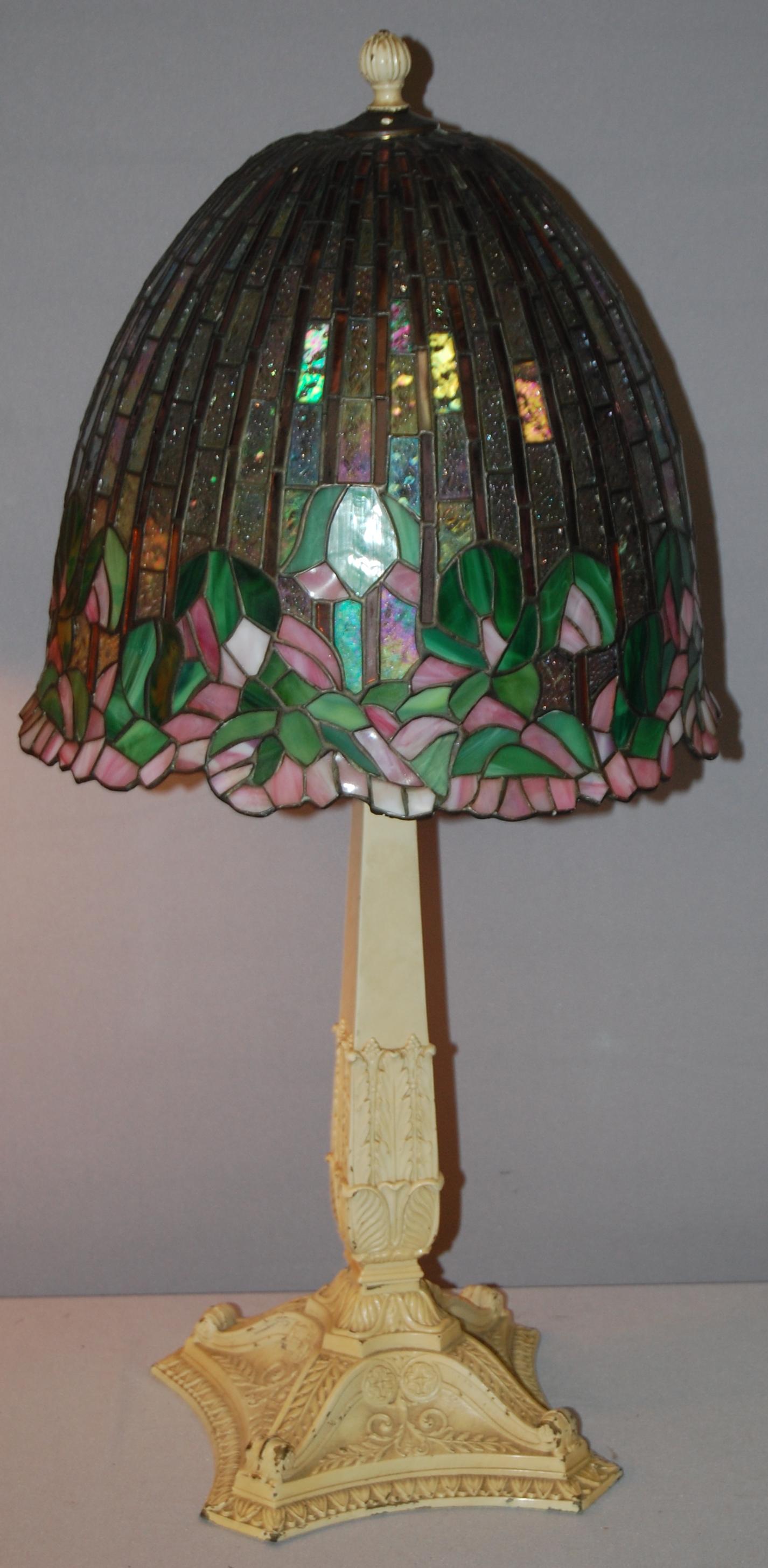 Signed Bradley & Hubbard Table Lamp w/ contemperary: Signed Bradley & Hubbard Table Lamp w/ contemperary leaded glass shade. Base has original old cream paint finish w/ 4 sockets w/ pulls- (3) are Bryant sockets. 29" Tall. Condition- Needs repaired. Som