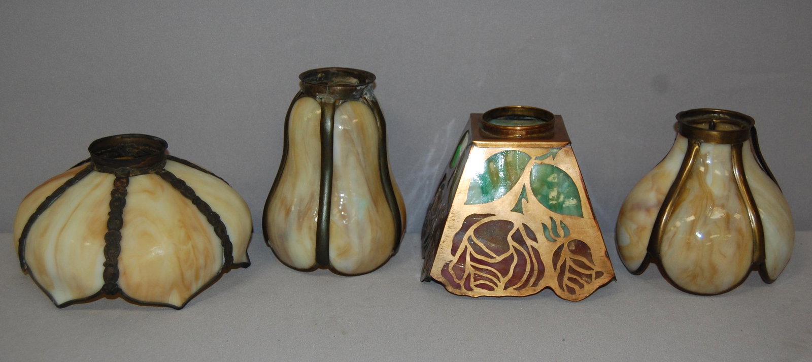 4 Slag Glass Lamp Shades. 1 copper floral cut out: 4 Slag Glass Lamp Shades. 1 copper floral cut out design, multi colored slag glass 2 1/8 fitter, 3 slag panel shades different shapes 2.25" fitters, 1 shade has loose trim