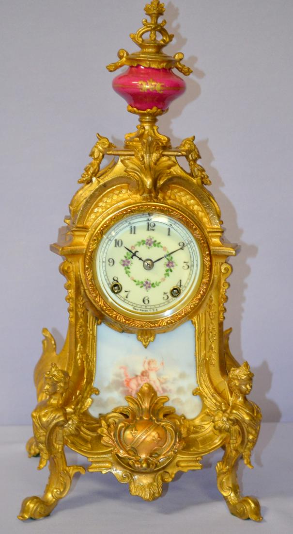 Antique New Haven (Sicilian) Ornate Clock: Antique New Haven (Sicilian) Ornate Clock, 3" decorated porcelain signed dial, Brass movement T&S French satin gold finish, painted porcelain panel & porcelain urn on top. 16 1/2" x 8" good condition