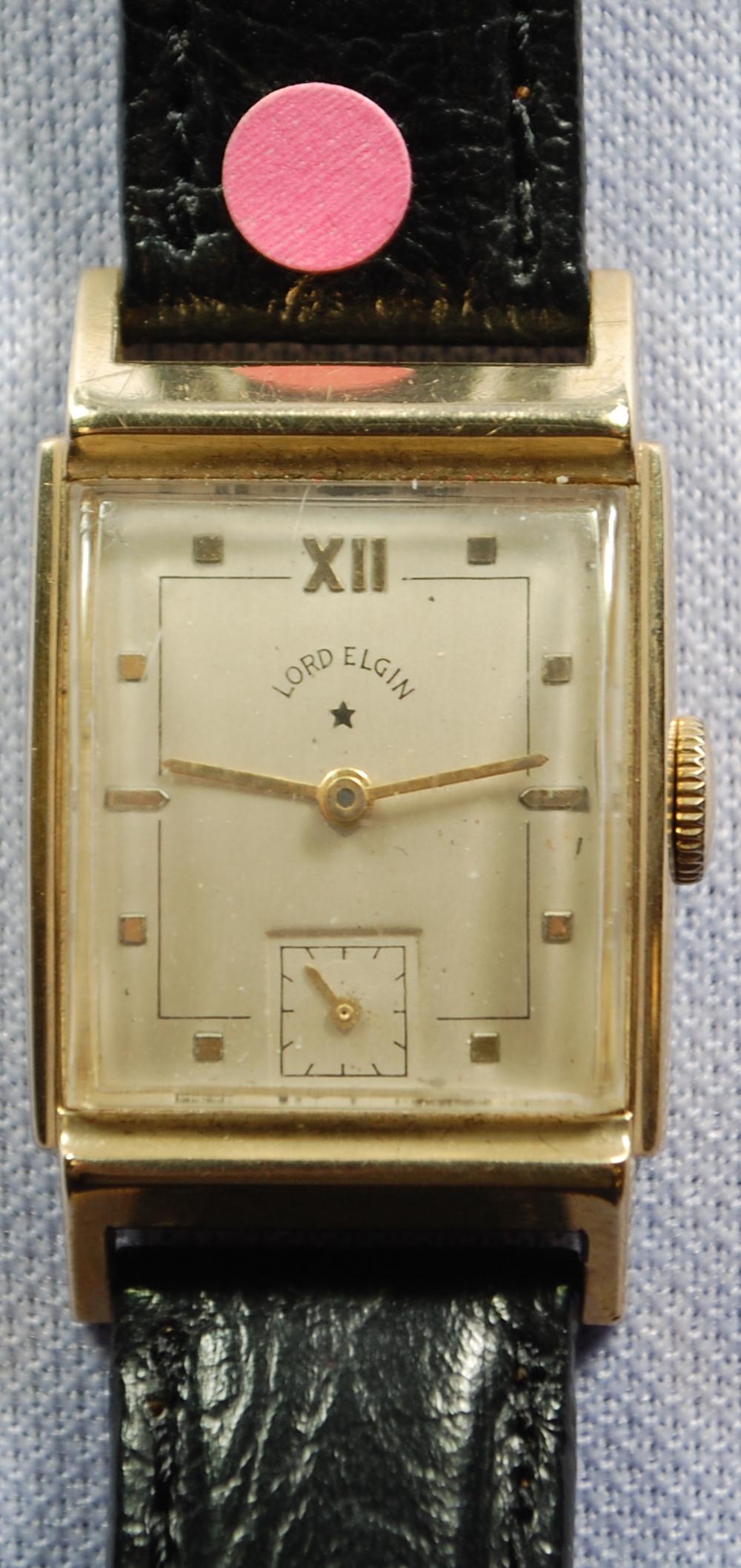 14K YG Lord Elgin 17J Men's Wrist Watch: 14K YG Lord Elgin 17J Men's Wrist Watch: 673, adjusted, No. R142392, the curved silver dial with gold numerals and black features shows some outer edge wear, inside case numbers 4518 and 261952, on a