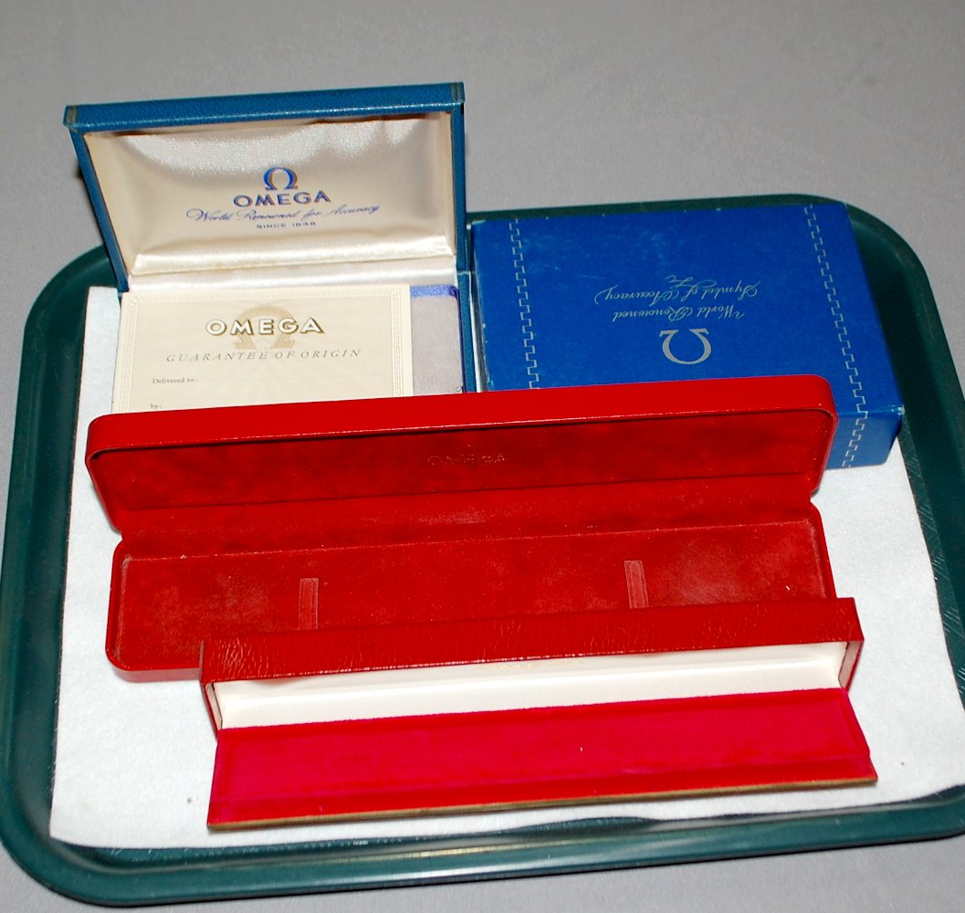 Lot of 3 Omega Wrist Watch Boxes: Lot of 3 Omega Wrist Watch Boxes: 1) blue with gray felt and outer box, 2) red with red and white felt, 3) red with red felt.