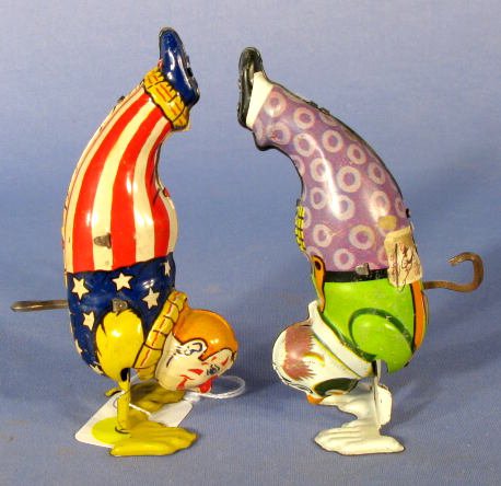 2 Chein Hands Down Clown Tin Litho Key Wind Toys: 2 Chein Tin Litho Hands Down Clown: they have different outfits on and are key wind activated. (The red and white clown is very clean with light scattered scratches. The purple clown has some brown sp