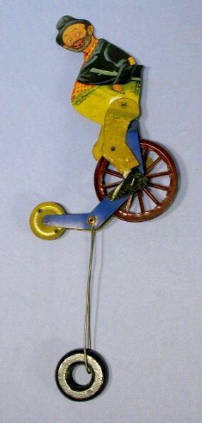 Hobo on Unicycle Tin Litho String Toy: Tin Litho Hobo on Unicycle String Toy: all original with counter balance. These were placed on a heavy piece of string tied to something. Wwhen released, it would cycle from one end to the other. No m