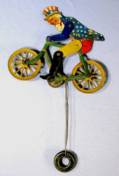 Uncle Sam on Bicycle Tin Litho String Toy: Tin Litho Uncle Sam on Bicycle String Toy: all original with counter balance. These were placed on a heavy piece of string tied to something. When released, it would cycle from one end to the other. N