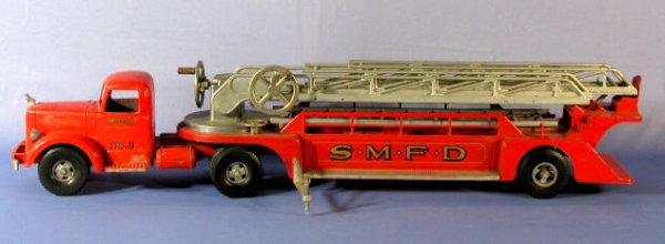 Smitty "L" Mack Aerial Ladder Truck Toy: Smitty "L" Mack Aerial Ladder Truck Toy: made by Smith Miller, it is marked "S.M.F.D. No.3" and has 8 wheels. The hand crank ladders extend to 40" in length. There are 2 straight ladders with it also.