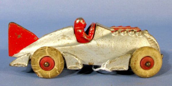 Hubley Toy Racer w/Driver & Large Tail Fin: Hubley Toy Racer w/Driver & Large Tail Fin: made of cast iron, signed and numbered 1877. The car is silver with red trim and rubber wheels. (The wheels are dried and creased. There is some worn and ch