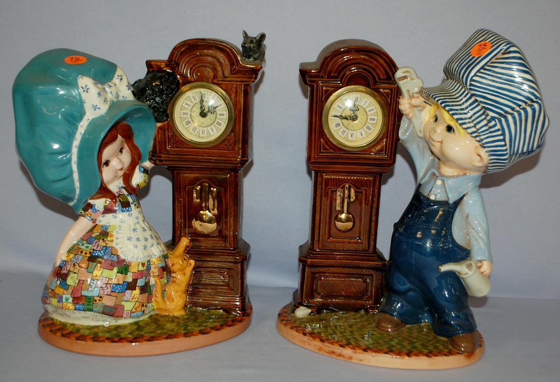 2 Vintage Minxie German Figure Clocks: 2 Vintage Minxie German Figure Clocks: 2 figural pottery clocks, one young lady w/ cat, one young man w/ tools. 12 1/2" x 8 1/2"