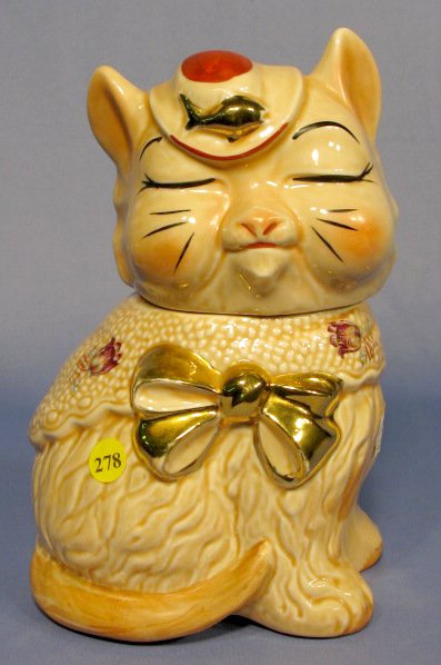 Cat w/Flowers Cookie Jar: Cat w/Flowers Cookie Jar: unknown maker. Fish on hat, long tail, gold trim, tulip decals. Same shape as Shawnee Puss N Boots. No condition problems. 10" tall All items sell As Is, Where Is, no guarant