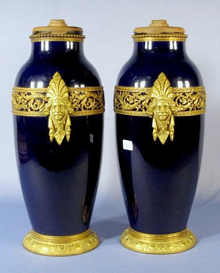 Pr. M.P. Sevres Cobalt & Ormolu Porcelain Vases: Pr. M.P. Sevres Porcelain Vases: both are cobalt blue in color and ormolu mounted. There is a bronze band of thistle like plants and 2 ladies head medallions on them. Each has a painted black wood cov
