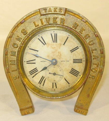 Ansonia Simmons Liver Regulator Alarm: Ansonia Simmons Liver Regulator Alarm: "Take in Time" is the rest of the wording. The case is brass with horseshoe front and is hammered. The dial also has Simmon's logo. (Not working. The dial is fad