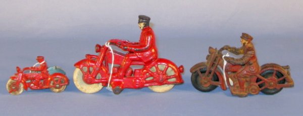 Group of 3 Cast Iron Motorcycle Toys: Group of 3 Cast Iron Motorcycle Toys: 1.) Patrol, red paint and flesh face, 6 1/2" (Worn rubber tires.) 2.) 271 cycle red paint and flesh face, 7" (Worn rubber tires.) 3.) Cop cycle with side car, red