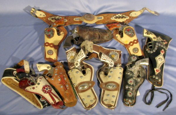 Group of 7 Cap Guns & Holsters: Group of 7 Cap Guns & Holsters: 1.) Double holster and cap gun set "Colt 38" cap guns, bone style grips, belt. (Worn) 2.) "Western" double set with longhorn grips, belt holster. (Worn) 3.) Buck'n Bron
