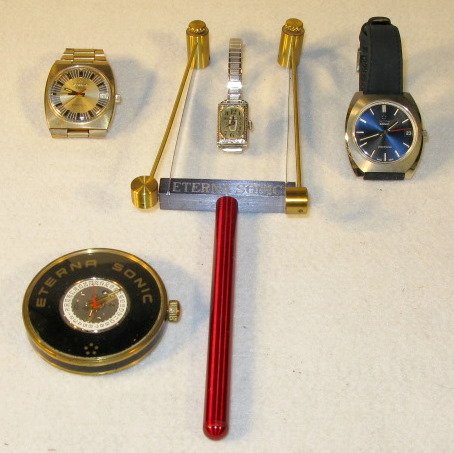 5 Eterna Sonic Items: 5 Eterna Sonic Items: 1.) Hand held turner, 9 1/2" long 2.) Gold filled wrist watch no.501TB8550. 3 tone dial with day wheel at the 3. Not tested. 3.) Cased demonstration only movement, numbered 1550.