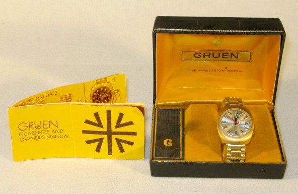 Gruen Precision Electronic Wrist Watch in Box: Gruen Precision Electronic Wrist Watch in Box: with auto wind feature. Stainless steel and base metal case. Not opened or tested. The silver dial has black and white hands and markers with a red secon